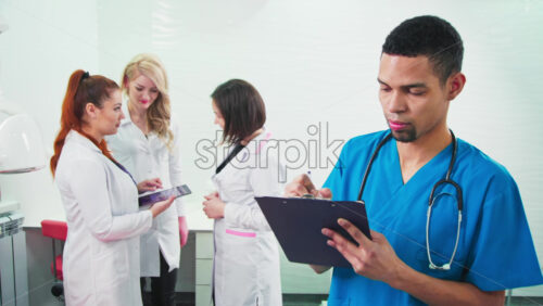 Video - Doctors in the dental office. Three talking nurses and one noting doctor