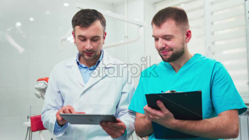 Video - Doctors in the dental office talking, making notes and using tablet