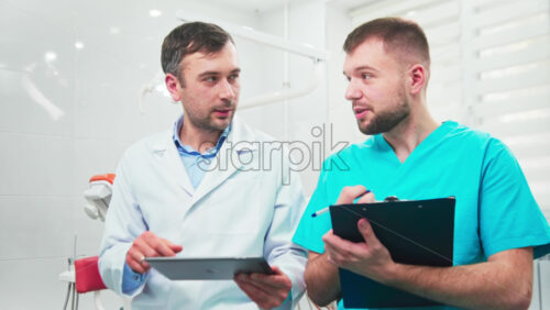 Video - Doctors in the dental office talking, making notes and using tablet