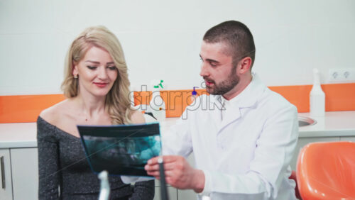Video - Doctor in the dental office talking with patient and looking at the roentgen image