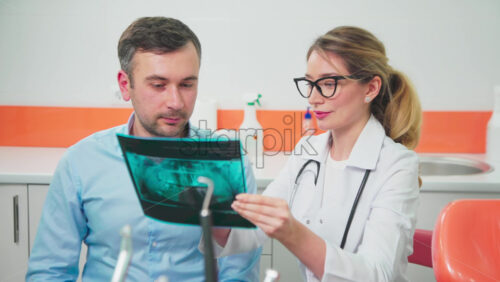 Video - Doctor in the dental office talking with patient and looking at the roentgen image