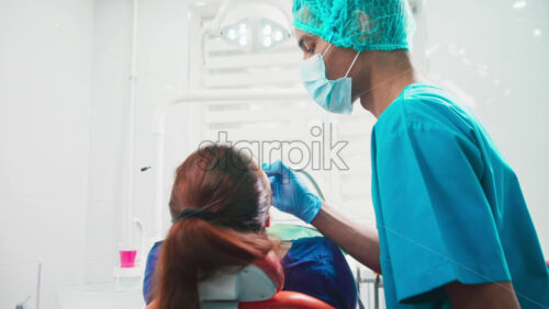 Video - Doctor using a device in the dental office with patient at the examination