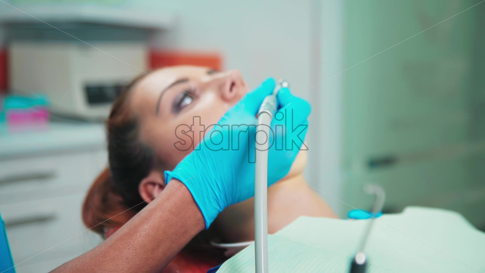 Video - Doctor using a device in the dental office with patient at the examination