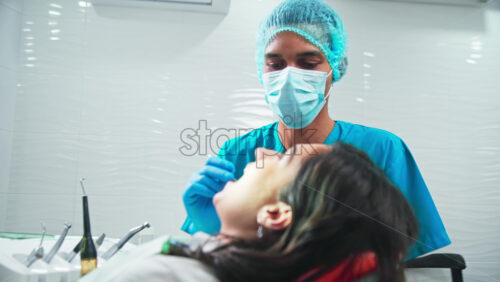 Video - Doctor in the dental office with patient at the examination, helping nurse