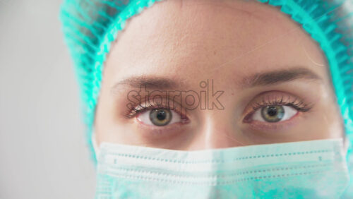 Video - Doctor in medical mask and hat in the dental office looking into the camera