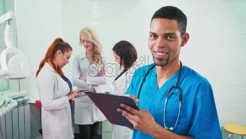 Video - Doctors in the dental office. Three talking nurses and one noting doctor looking into the camera