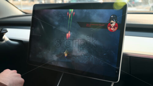 Video - Chisinau, Moldova - January 23, 2024: Male hands playing games on the touch screen of Tesla electric car