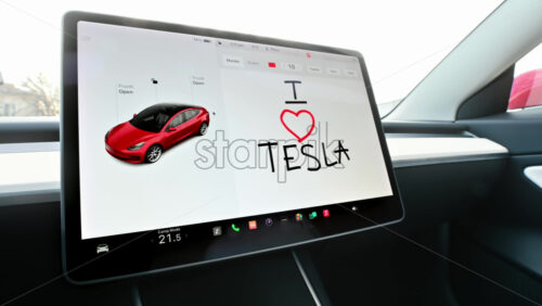 Video - Chisinau, Moldova - January 23, 2024: "I love Tesla" drawn text in the Sketchpad application of the red Tesla Model 3 electric car. Light theme