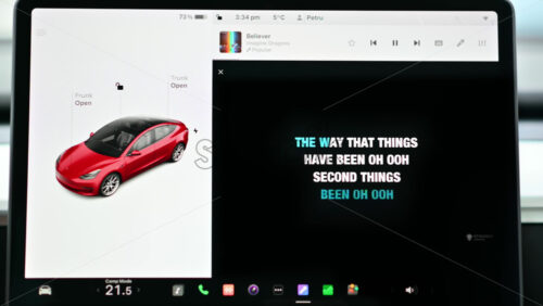 Video - Chisinau, Moldova - January 23, 2024: Caraoke application on the screen of the red Tesla Model 3 electric car. Light theme
