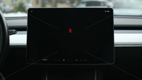 Video - Chisinau, Moldova - January 23, 2024: Timelapse of male hands navigating through the menus and entertainment applications on the touch screen of the red Tesla Model 3 electric car. Dark theme