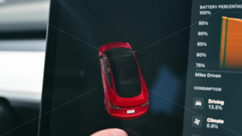 Video - Chisinau, Moldova - January 23, 2024: Male hands rotating the 3D model of red Tesla Model 3 electric car in the status area of the touch screen. Dark theme