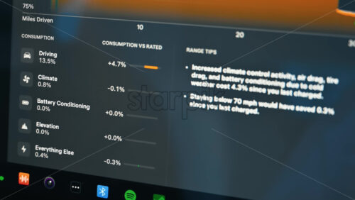 Video - Chisinau, Moldova - January 23, 2024: Tesla Model 3 energy consumption graph on the touch screen inside the red electric car. Dark theme