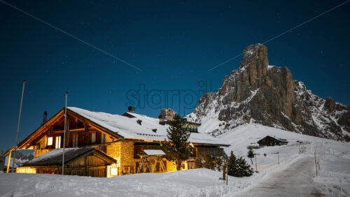 Video - Timelapse of chalet and mountains of Passo Giau at night with stars and blue sky