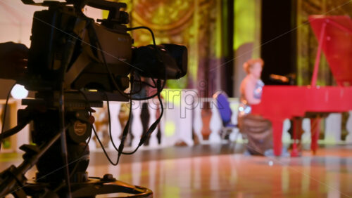 Video - Professional camera filming a woman playing the piano on the backstage of a TV set