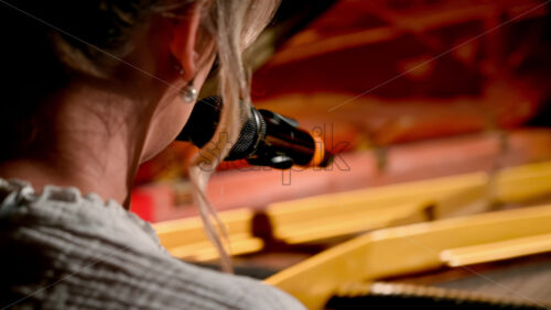 Video - Woman singing into the microphone and playing a red piano