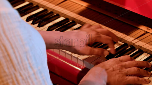 Video - Elderly woman playing a red piano