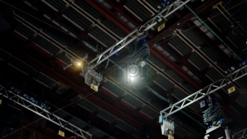 Video - Drone flying and filming near flashing studio lights equipment on the ceiling of a TV set
