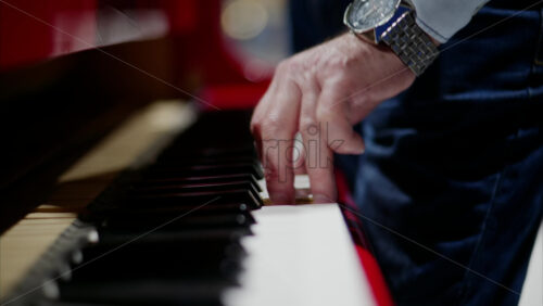 Video - Close up of a man playing a red piano