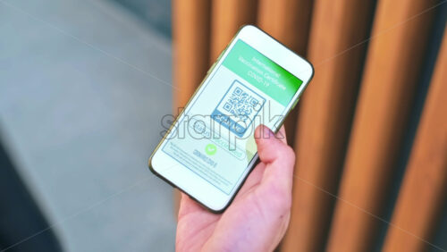 Video - Male hand holding a smartphone with International Vaccination Certificate COVID-19 QR code