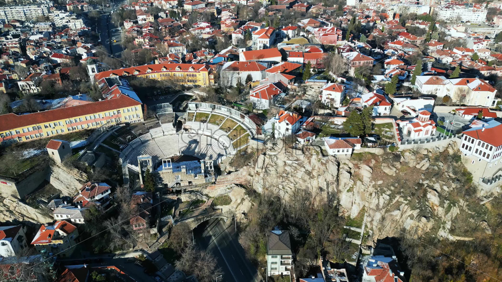 Video - Aerial drone view of the ancient Theatre of Philippopolis. Orange roofs covered in snow. The city center of Plovdiv, Bulgaria