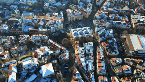 Video - Aerial drone view of the city center of Plovdiv. Orange roofs covered in snow. Bulgaria