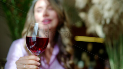 Video - Close-up of woman savouring a glass of red wine in daylight