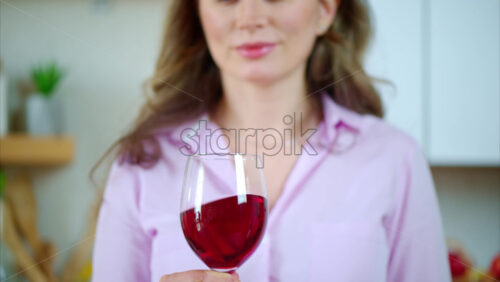 Video - Woman swirling a glass of red wine in the kitchen