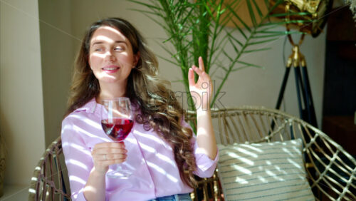 Video - Woman enjoying a glass of red wine and dancing in the daylight