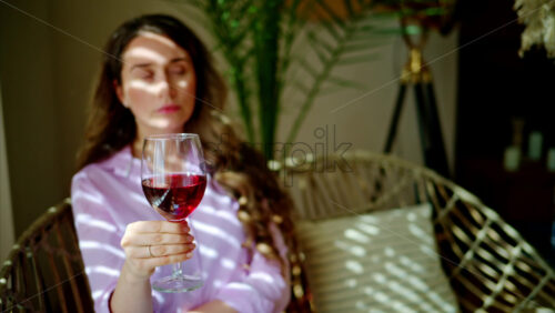Video - Woman savouring a glass of red wine in daylight