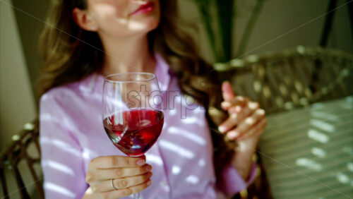 Video - Woman enjoying a glass of red wine and dancing in the daylight