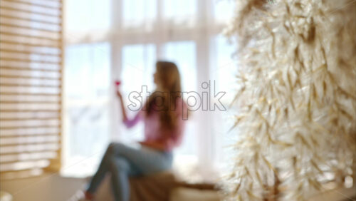 Video - Woman enjoying a glass of red wine, near a window in the barn