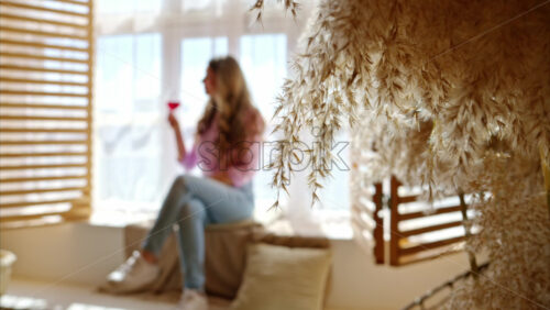 Video - Woman enjoying a glass of red wine, near a window in the barn