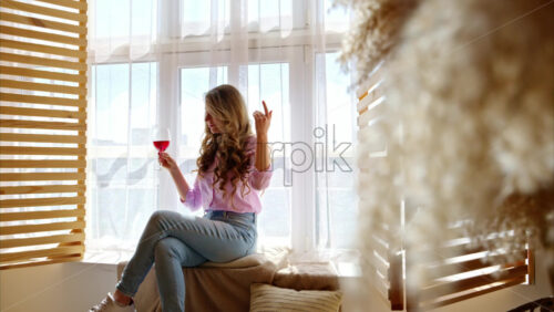 Video - Woman enjoying a glass of red wine, near a window in the barn