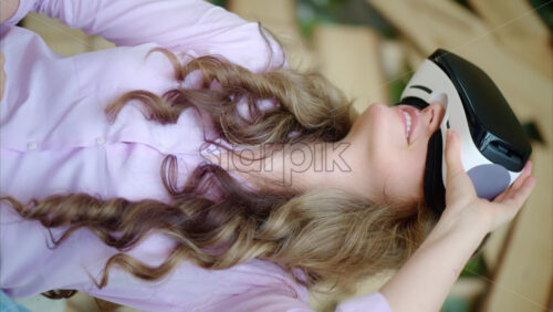 Video - Woman putting on VR headset and enjoying it. Vertical