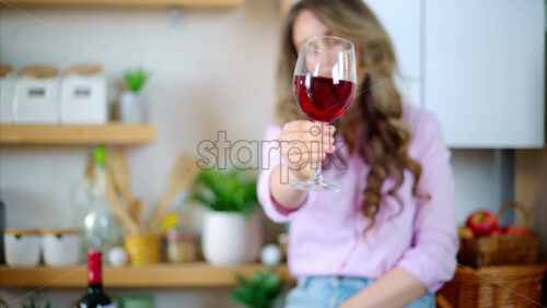 Video - Woman enjoying a glass of red wine in the kitchen