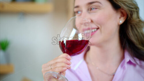 Video - Woman enjoying a glass of red wine in the kitchen