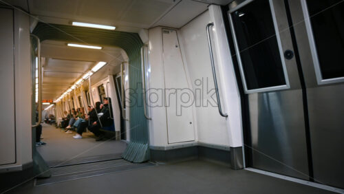 Video - Bucharest, Romania - March 02, 2024: Subway train with people sitting on the benches