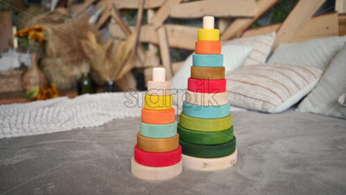 Video - Colourful, ecological wooden toys sitting on bed with rustic decor on the background