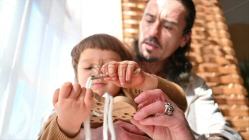 Video - Father playing with his son with ecological wooden toys near the window