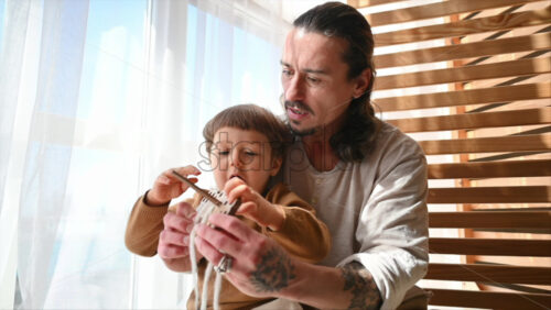 Video - Father playing with his son with ecological wooden toys near the window