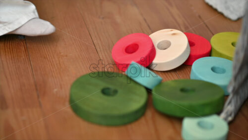 Video - Child playing with colourful, ecological wooden toys on the floor