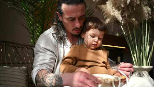 Video - Father playing with his son with ecological wooden toys on a day bed