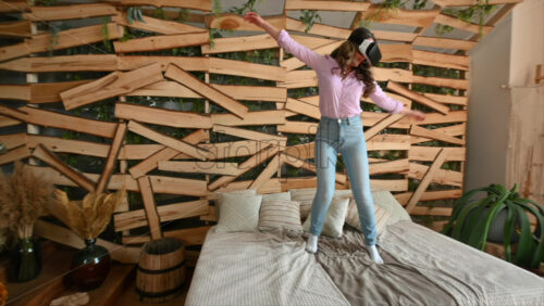 Video - Woman looking through VR headset and jumping on bed