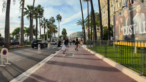 Video - Cannes, France - September 20, 2025: Elegant boulevard of the Croisette with palm trees and luxury hotels with people walking along the famous seafront