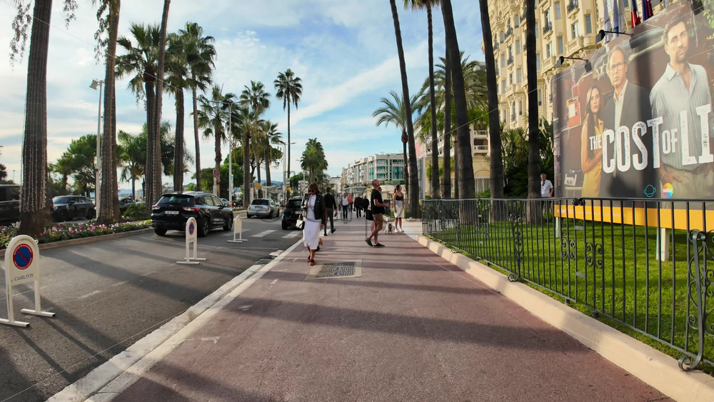 Video - Cannes, France - September 20, 2025: Elegant boulevard of the Croisette with palm trees and luxury hotels with people walking along the famous seafront