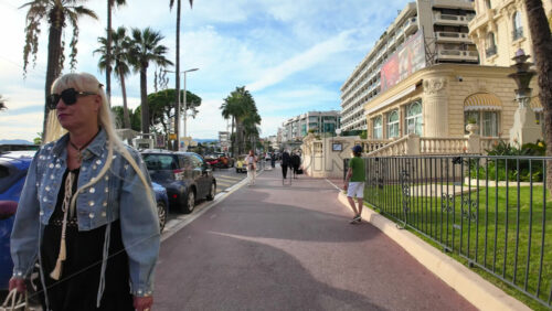 Video - Cannes, France - September 20, 2025: Elegant boulevard of the Croisette with palm trees and luxury hotels with people walking along the famous seafront
