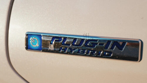 Video - Shining close up of a plug in hybrid badge on a car under sunlight