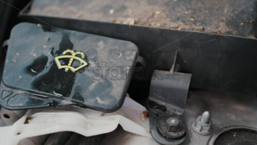Video - Close up of a car's windshield washer fluid cap with water droplets