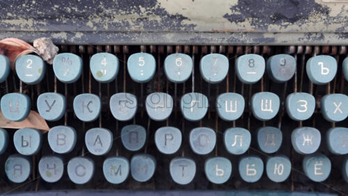 Video - Rustic close up of an old cyrillic typewriter with plants growing near it