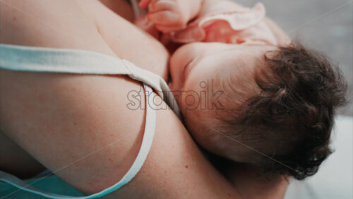 Video - Tender moment of a mother nursing her baby in natural light in the park